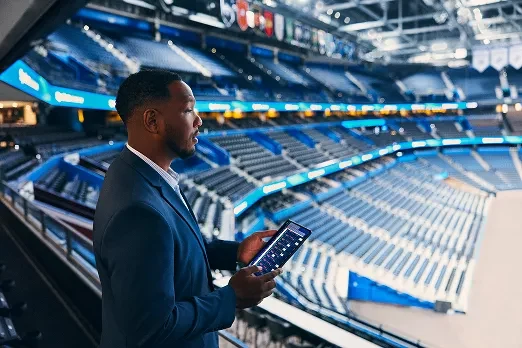 Business professional reviewing a large venue with a tablet